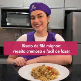 Mulher sorrindo usando uniforme roxo da Mary Help, em uma cozinha, ao lado de um prato de risoto de filé mignon. A imagem destaca o texto “Risoto de filé mignon: receita cremosa e fácil de fazer”.