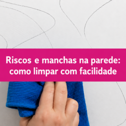 Parede branca com riscos e manchas sendo limpa com um pano de microfibra azul, acompanhada do texto “Riscos e manchas na parede: como limpar com facilidade”.