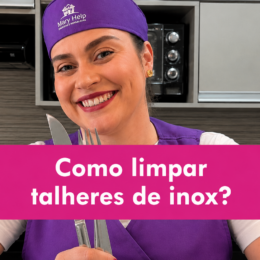 Mulher usando uniforme roxo da Mary Help segura talheres de inox em uma cozinha, acompanhada da chamada “Como limpar talheres de inox?” em destaque no centro da imagem.