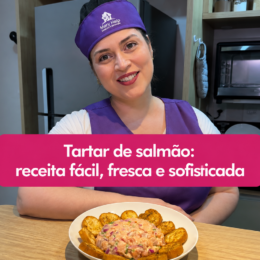 Tartar de salmão cremoso servido em prato branco, acompanhado de torradas crocantes e temperado com cebola roxa e ervas.